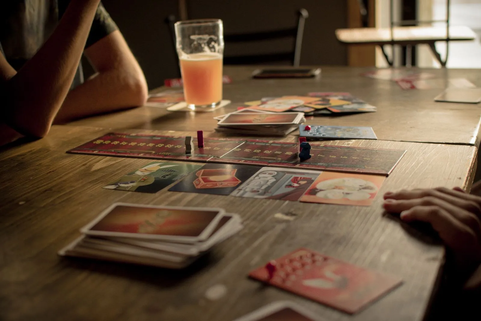 People playing a board game at a café table, capturing leisure and social interaction.